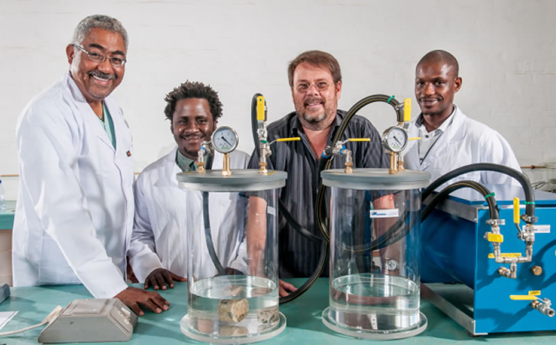 Delegates working with materials-testing apparatus in a laboratory